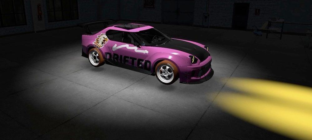 A pink car lit by a spotlight in a dark garage