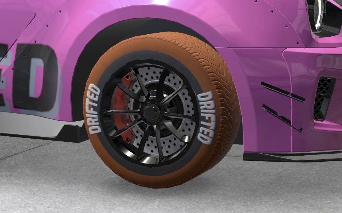 Close-up of a black alloy wheel with brake disc and orange tyre